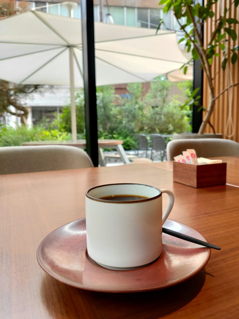 A tranquil café scene in Taito City, Tokyo, with a cup of coffee on a wooden table.